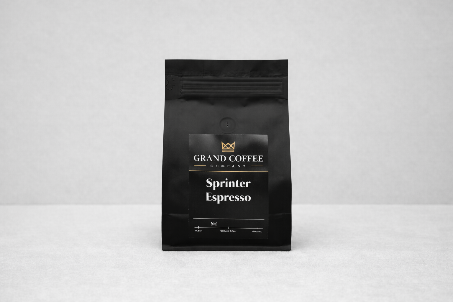 Black coffee bag labeled 'Sprinter Espresso' from 'Grand Coffee Company' on a light gray background