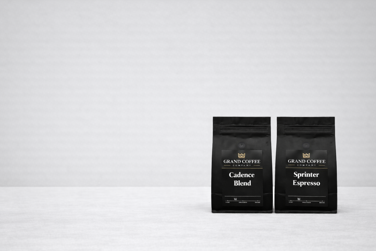 Two black coffee bags labeled 'Cadence Blend' and 'Sprinter Espresso' on a white background